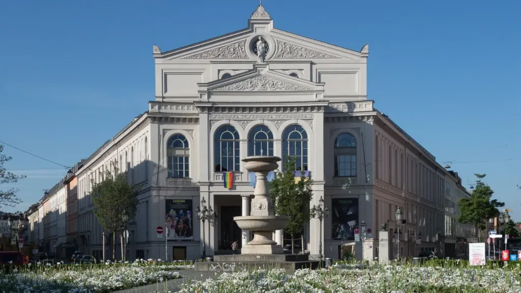Imponujący budynek opery z fontanną na pierwszym planie w słoneczny dzień