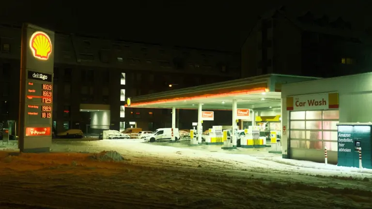 Stacja paliw Shell w zimowej scenerii z widocznym pylonem cenowym wieczorem.