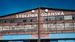 Historyczna hala Stoczni Gdańskiej z charakterystycznym napisem na ceglanej fasadzie budynku.