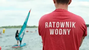 Ratownik wodny obserwujący jezioro podczas zawodów sportowych w Polsce w słoneczny dzień.